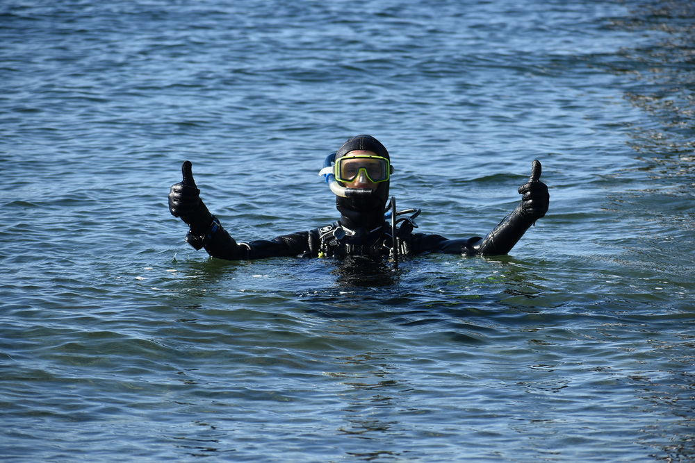 Student in scuba gear giving a thumbs up in the water