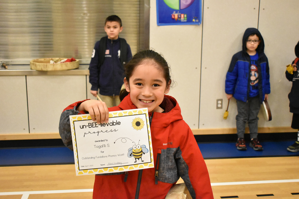 student holding up certificate smiling