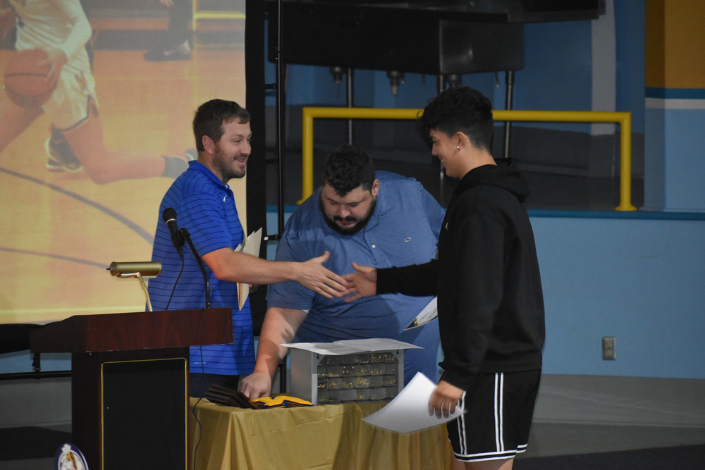 student shaking hands with coach at award ceremony