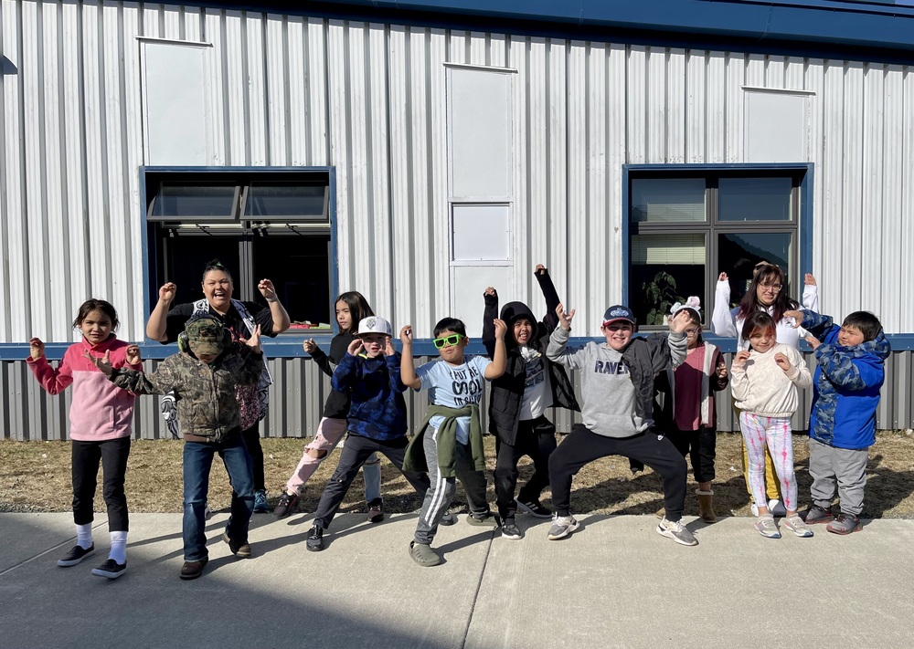 students posing like crabs in front of school