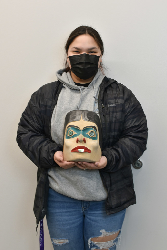 Alicia holding her mask she created in Native Arts