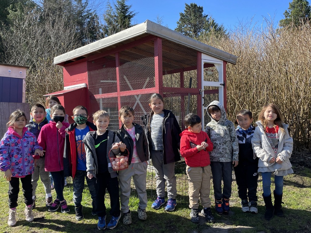 students stand in front of a chicken coop