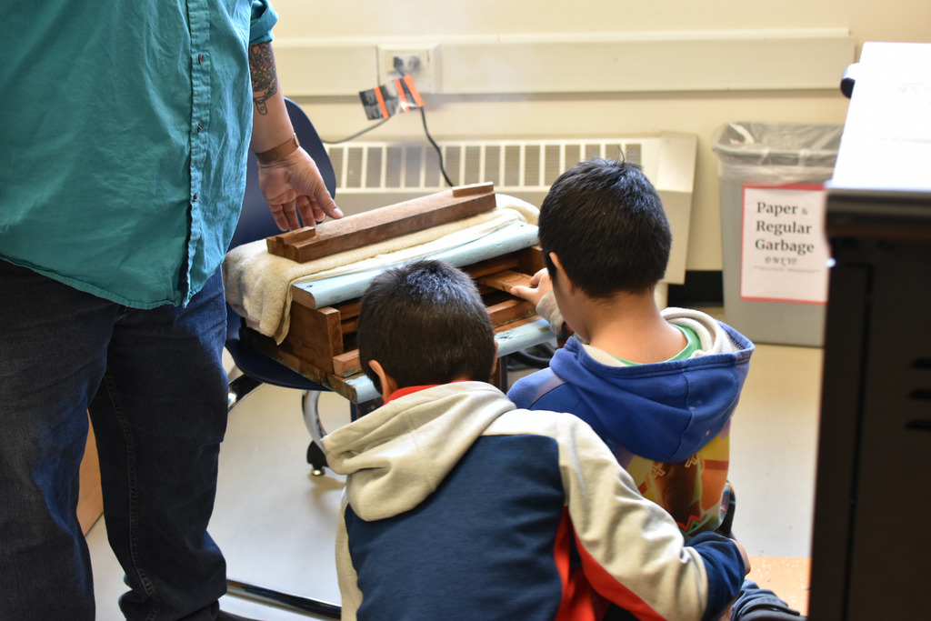 students looking at wood in the steam box