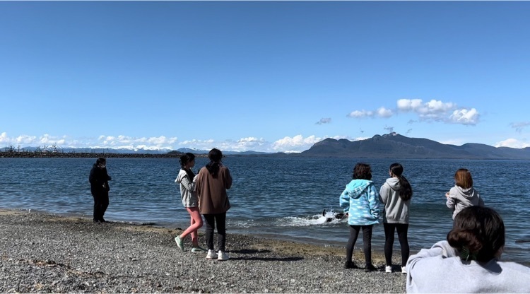 students roasting s’mores on the beach