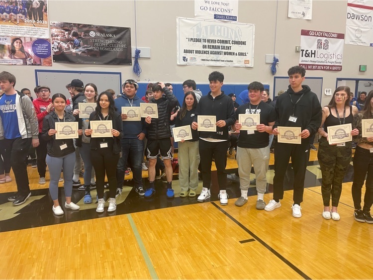 students holding certificates in a gym
