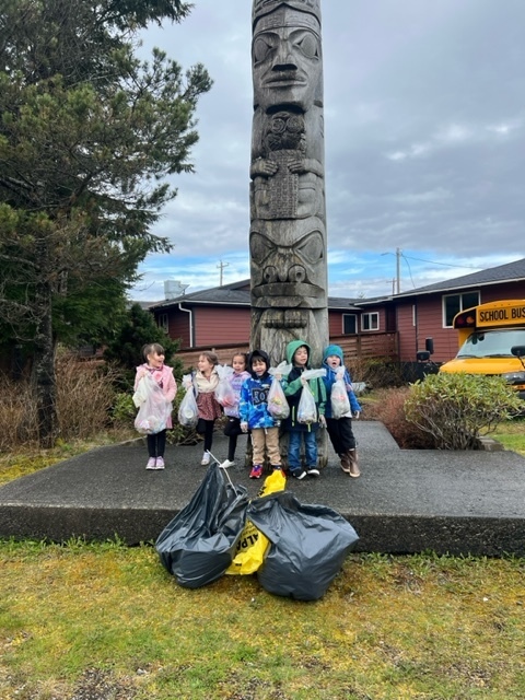 students smiling holding garbage bags