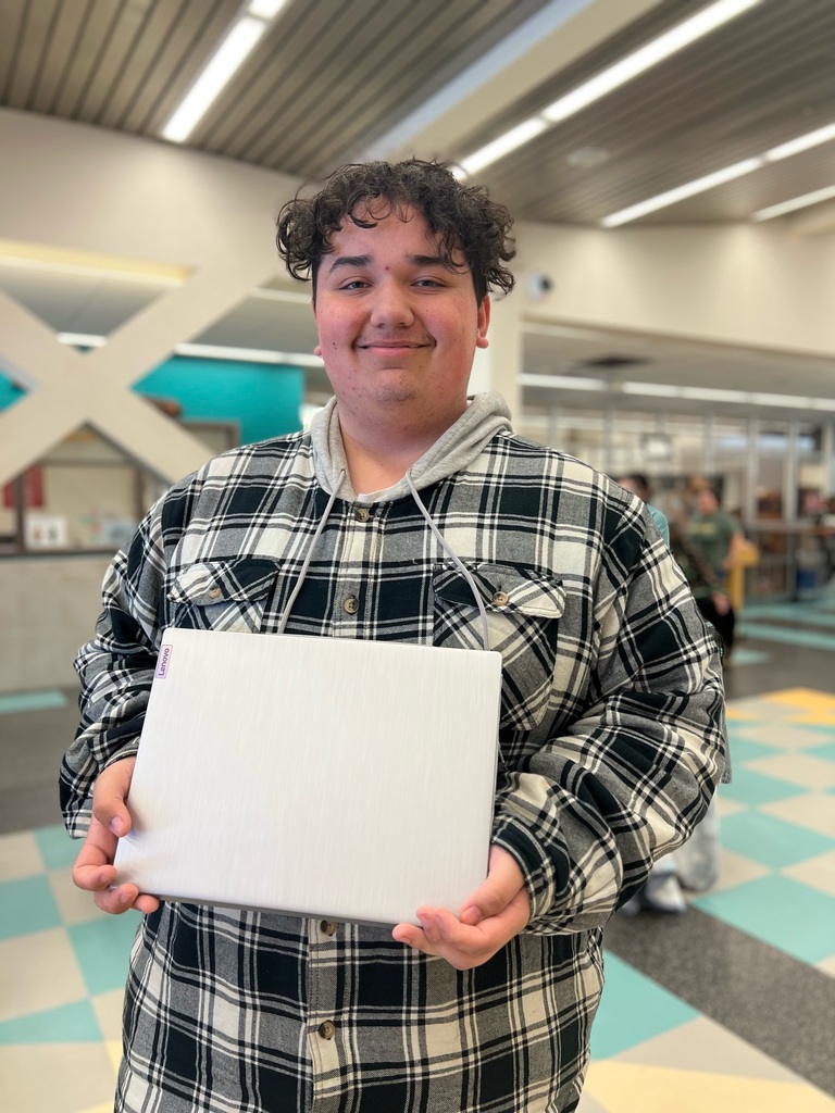 picture of student holding a laptop in a school