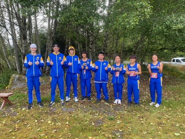 students in cross country uniforms giving thumbs up